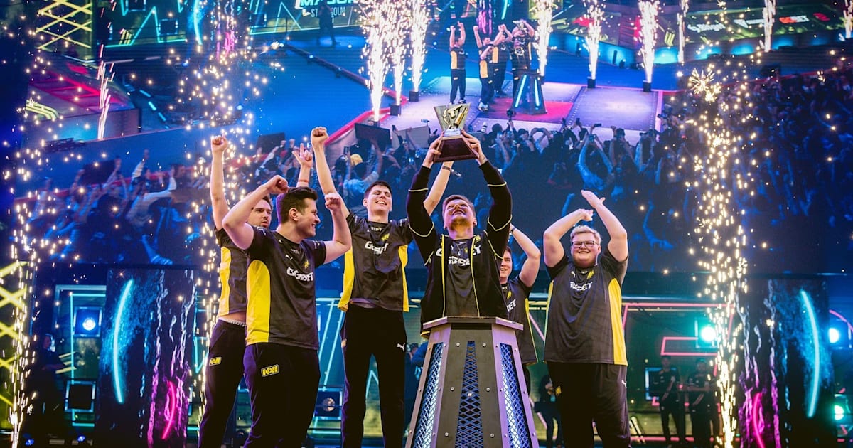 команда киберспортсменов за компьютерами на сцене под софитами