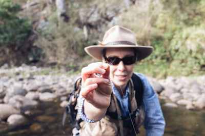 Person holds fishing line towards camera during a fly fishing trip.