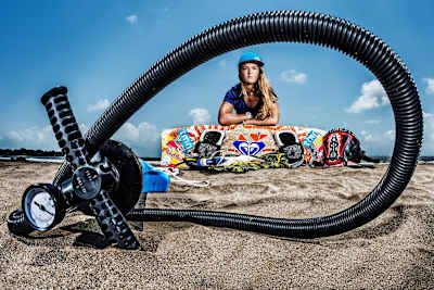 Ines Correia on the beach with her surfboard, photographed through a tube. 