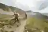 Claudio Caluori and Danny MacAskill ride up a mountain track in Switzerland.