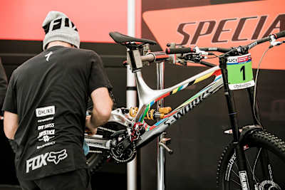 Finn Iles's Specialized S-Works Demor MTB tended to by a mechanic at the Lourdes World Cup in 2017