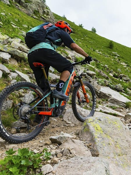 Rider on e-bike on rocky singletrack.