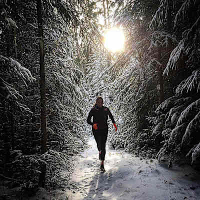 Carrera invernal por un bosque nevado.