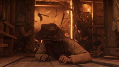 Screenshot of Red Dead Redemption 2 showing a character on the floor as the background explodes