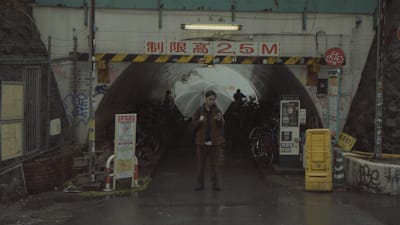 A photo of tofubeats checking his phone.