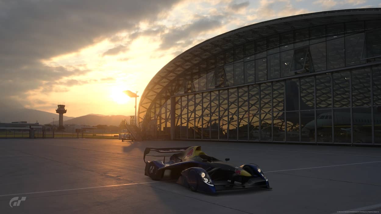 Ảnh chụp màn hình từ Gran Turismo 7 cho thấy Red Bull X2014 Junior phía trước Hangar-7