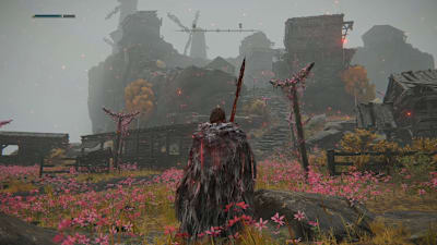 Blumen überziehen einen Hügel auf dem Windmühlen thronen