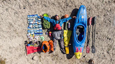 Adrian Mattern seen from above as he lays with his kayak and equipment during his kayaking expedition to the Sary-Jaz river in Kyrgyrzstan's Tian Shan mountains.