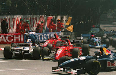 A photo of stewards stopping the 1995 Monaco Grand Prix and David Coulthard leaving his car after crashing with Jean Alesi and Gerhard Berger.
