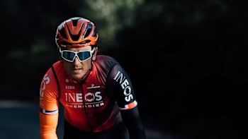 Welsh cyclist Geraint Thomas seen riding in the black and orange uniform of the Ineos Grenadiers team.