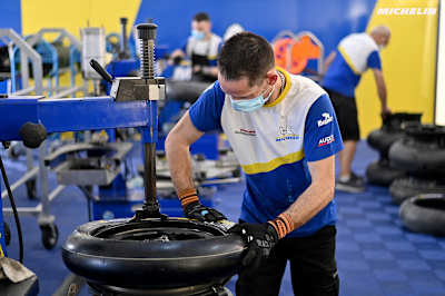 Un técnico de Michelin monta un neumático en la llanta.