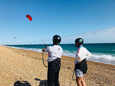 A kitesurfing instructor teaches a lesson.