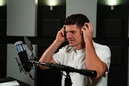 German football legend Mario Gómez in front of the mic in the studio for Red Bull's Mind Set Win podcast.