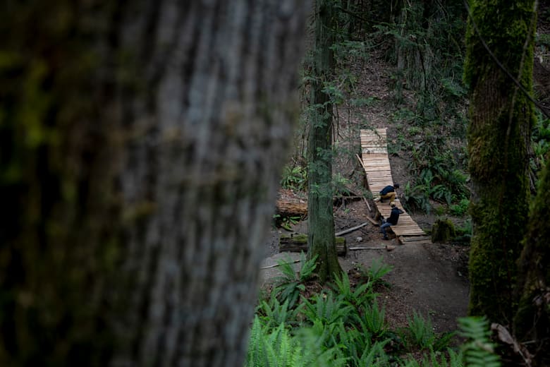 Ο MTB αθλητής Darren Berrecloth και ο φίλος του συνθέτουν μια ξύλινη κατασκευή σε ένα μονοπάτι κοντά στο σπίτι του στο Parksville της Βρετανικής Κολομβίας.