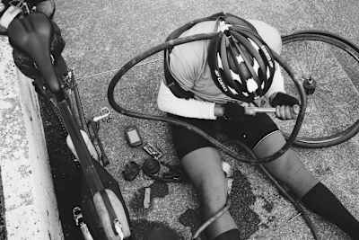 A cyclist pumps up a inner tube with a mini-air pump.