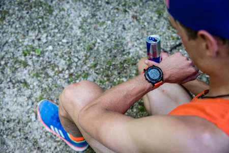 Skibergsteiger und Bergläufer ANton Palzer blickt auf seine Smart-Watch. Sie zeigt die Daten seines unglaublichen Sub3-Rekords bei der Watzmann-Überschreitung.