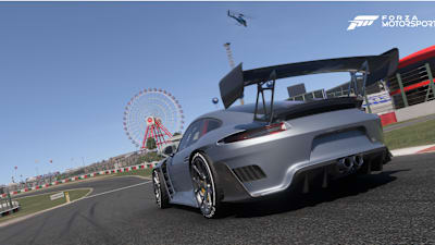 Captura de pantalla de Forza Motorsport muestra un Porsche gris en Suzuka con la noria de fondo.