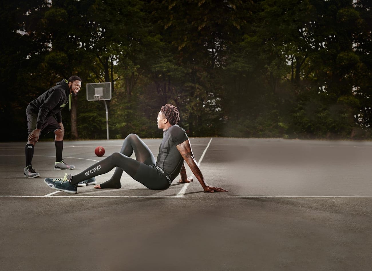 Two people play basketball wearing compression wear.