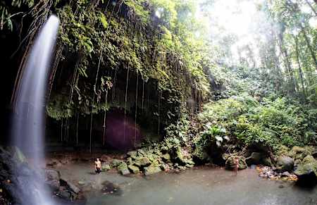 People stand next to Emerald Waterfall in Dominica.