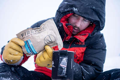 Man at altitude makes food from rehydrated meal packs.