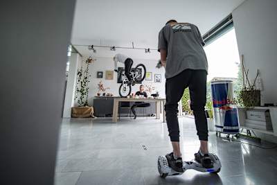A cameraman rides on a hoverboard to capture Fabio Wibmer riding his bike during filming of his video Home Office.