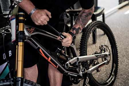 Aaron Gwin's mechanic John Hall plays around the the YT Tues rear shock settings.