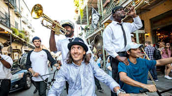 Musicians get a backie on a BMX at a Second Line Parade in New Orleans.