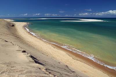 Praia de areia clara e mar azul-turquesa.