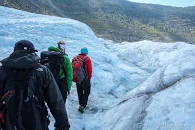 Three people walking on a glacier in Switzerland.