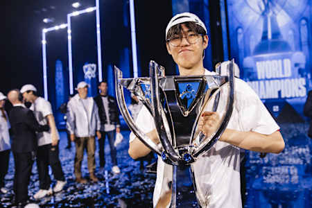 Le joueur de T1 Oner porse avec le trophée des Worlds de League of Legends.