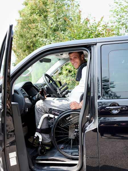 Mit einem hydraulischen Lift kann Wolfgang im Rollstuhl auf Fahrerposition.