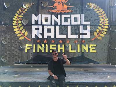 A photo of DJ Krakota at the Mongol Rally finish line in Russia.