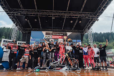 Les membres de l'équipe Commencal Muc Off sur le podium de la dernière course de la Coupe du monde de VTT descente 2022 à Val Di Sole, en Italie.