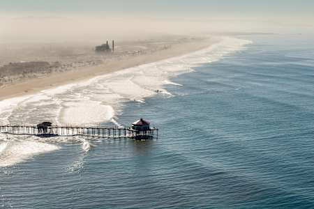 Swell lines break along the coast at Huntington Beach, California, USA.