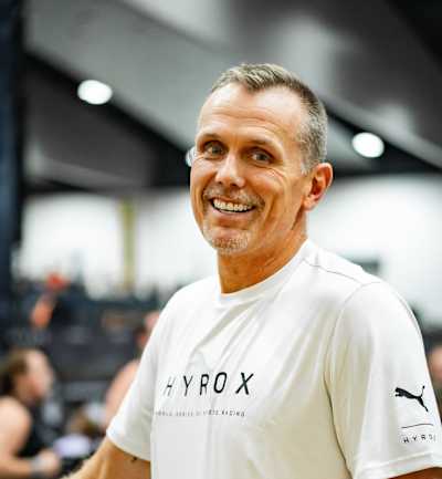 Mat Lock sourit en portant une chemise HYROX : Il est le nouveau directeur technique d'Elite Racing. 