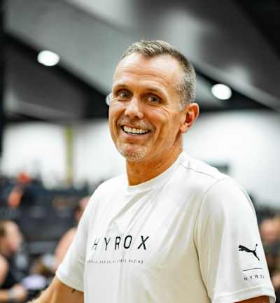 Mat Lock sonriendo con una camiseta de HYROX: Es el nuevo Director Técnico de Elite Racing.