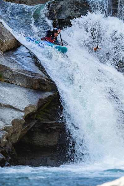 A photograph of French kayaker Nouria Newman taming the currents of the Devil's Slide canyon followed by a drone in northern Italy.