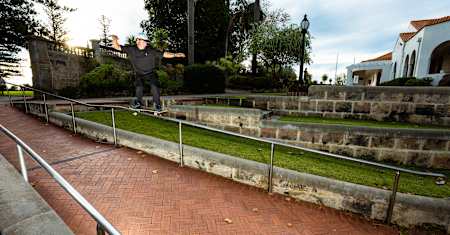 Cross-locked trucks holding on for dear life on a chrome rail in suburban Perth