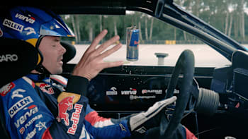 Kuba Przygoński łapie puszkę Red Bulla w swojej Toyocie GT86