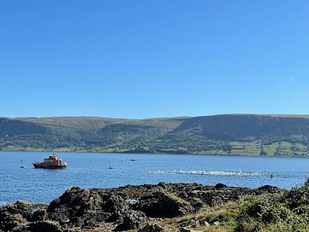 Athletes competing in the GOAT Triathlon at Cushendall, Ireland set against the scenic backdrop of the Glens of Antrim.