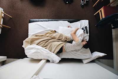 Person sleeps in bed at home.