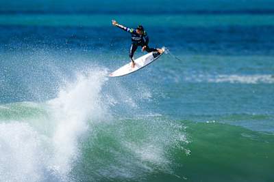 Italo Ferreira performs an aerial while surfing at the 2024 MEO Rip Curl Pro Portugal 