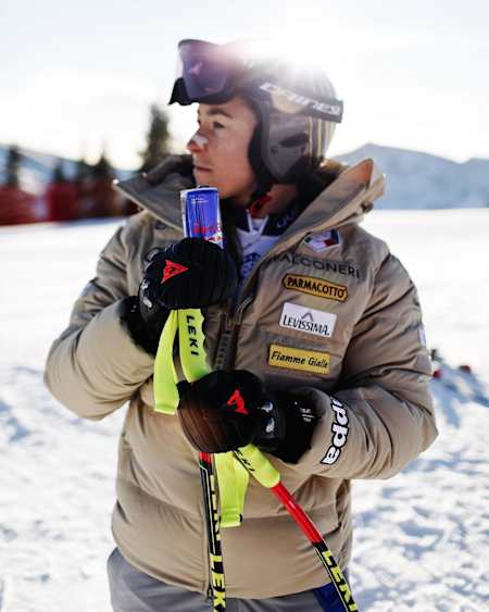 Sofia Goggia poses in ski gear with a can of Red Bull.