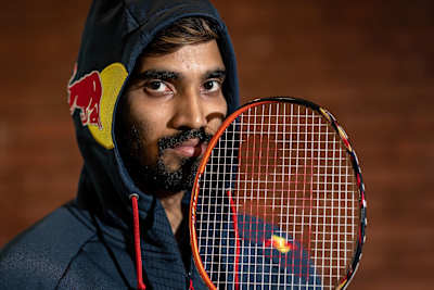 Indian badminton player Srikanth Kidambi poses for a photo while holding a badminton racquet.