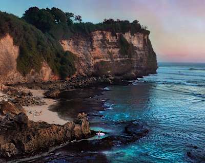 Kelly Slater walks out to surf at Uluwatu in Bali, Indonesia.