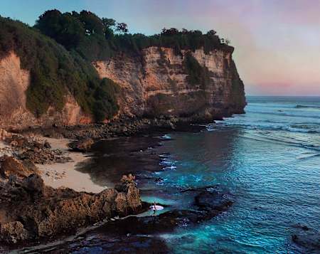 Kelly Slater walks out to surf at Uluwatu in Bali, Indonesia.