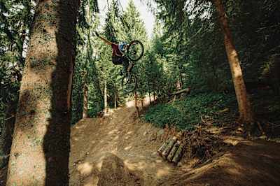 Martin Söderström performs a no-hander trick off a trail jump at Châtel MTB Park.