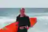 Julian Wilson walks on the beach in Australia after a surf.