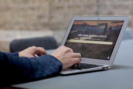 A photo of the Tribalingual website on a laptop.