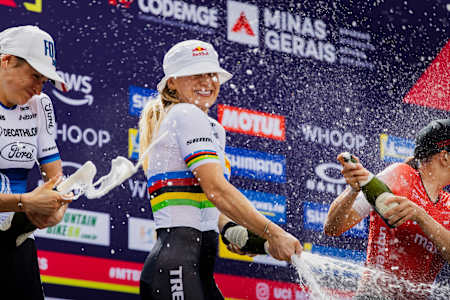 Evie Richards beams with joy during the UCI XCC World Cup celebration ceremony in Araxá, Brazil, April 2025, as she pops champagne alongside fellow competitors.
